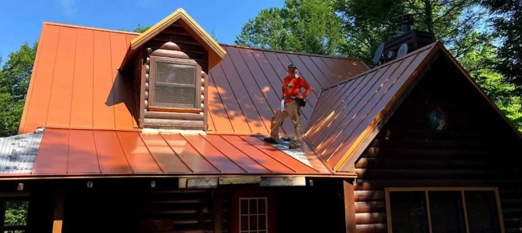 Crew installing a new metal roof on a log home