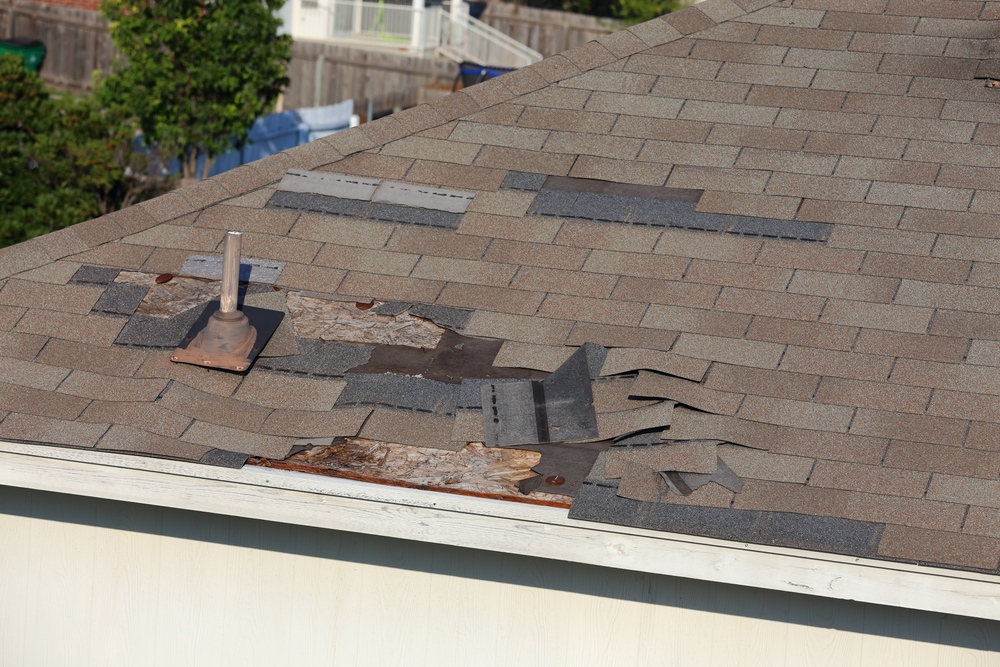 A close up view of shingles being blown off a roof and other roof damage in Albert lea, MN