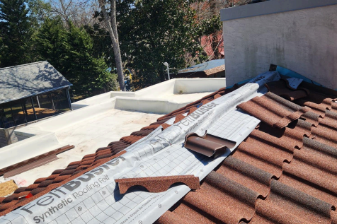 Roofing crew removing old asphalt shingles from a residential home in East Tennessee