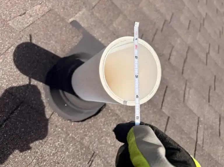 Close-up of PVC plumbing vent pipe and flashing assembly on a residential shingle roof in Crossville, TN.