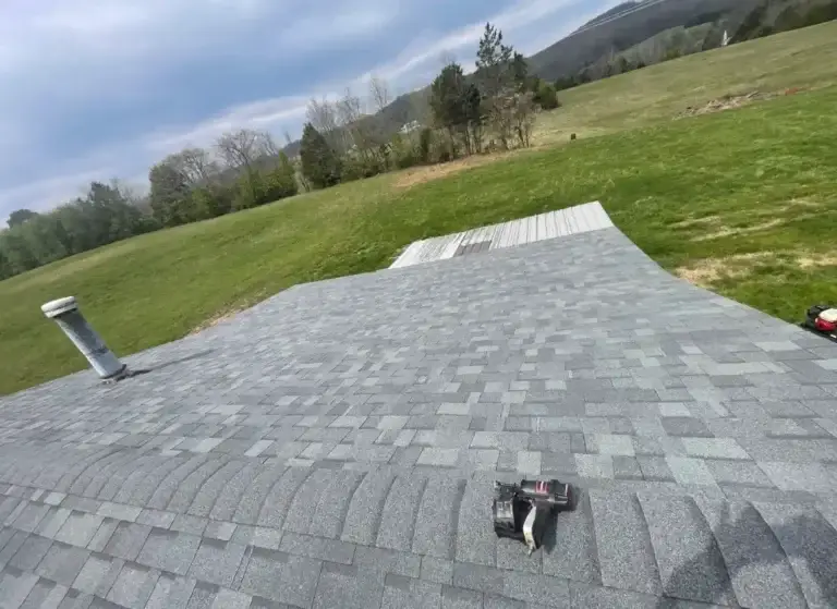 Residential roof replacement featuring architectural shingles and ridge cap installation
