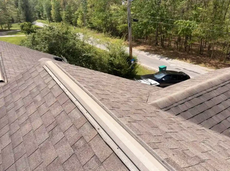Close-up view of aging aluminum ridge vent system on an asphalt shingle roof showing areas contributing to premature roof wear in Crossville, TN.