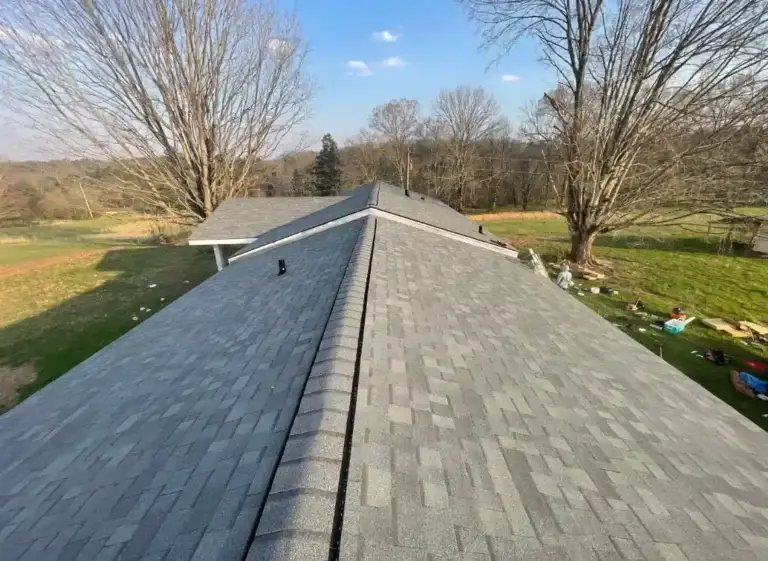 Finished roofing project showing durable gray shingles and clean ridge line
