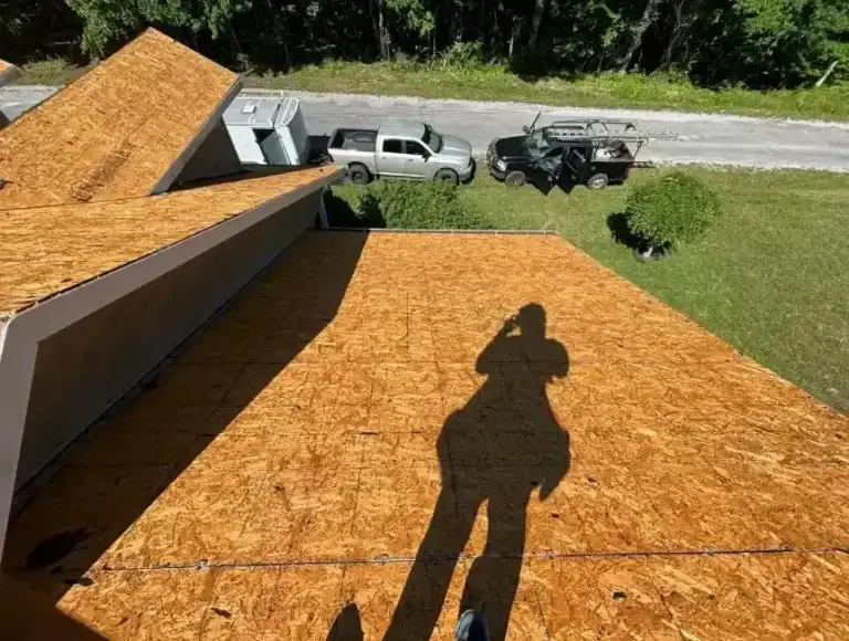 Freshly installed OSB roof sheathing on a low-slope rear addition during a roof replacement project in Crossville, TN.