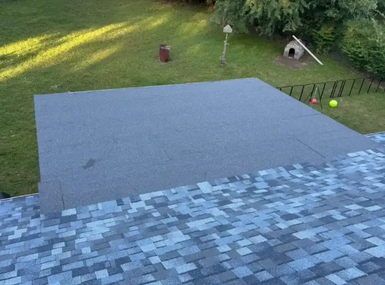 Finished low-slope rear addition with rolled roofing connected to new asphalt shingles in Crossville, TN.