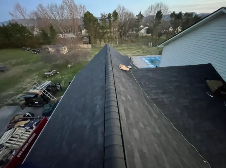 New ridge vent and asphalt shingles installed on a residential roof to improve attic ventilation and performance.