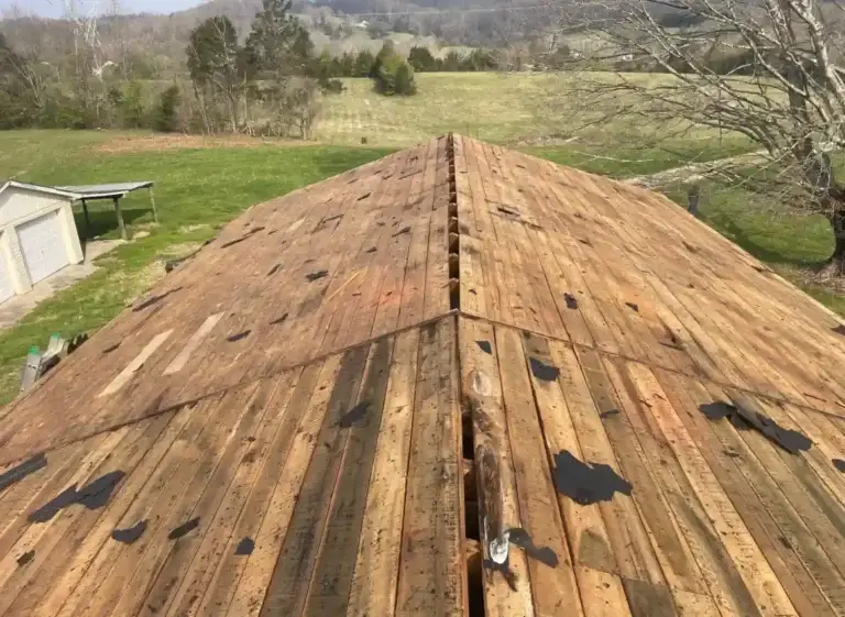 Old shingles removed during roof replacement project exposing original wood roof decking