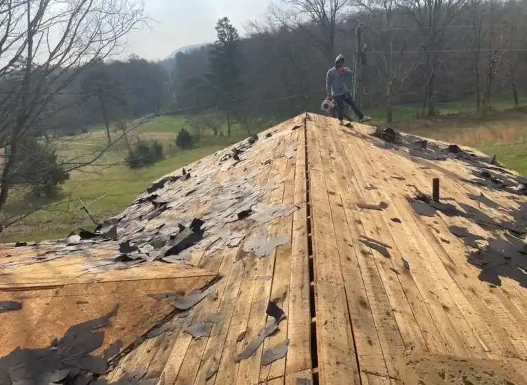 Roofing crew removing old shingles before installing a new roofing system