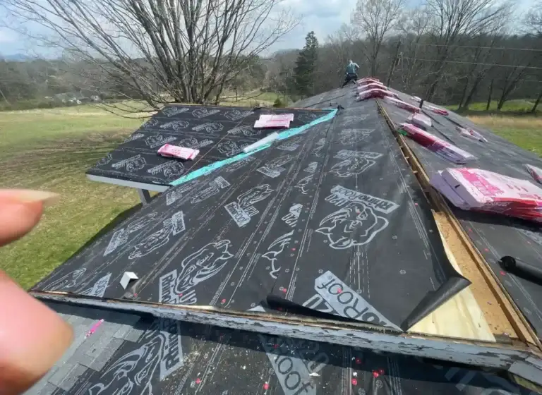 Roof underlayment installation in progress with roofing materials staged for replacement project